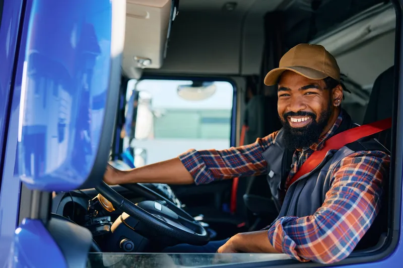 rs=w_800,cg_true,m A man sitting in the drivers seat of a truck.