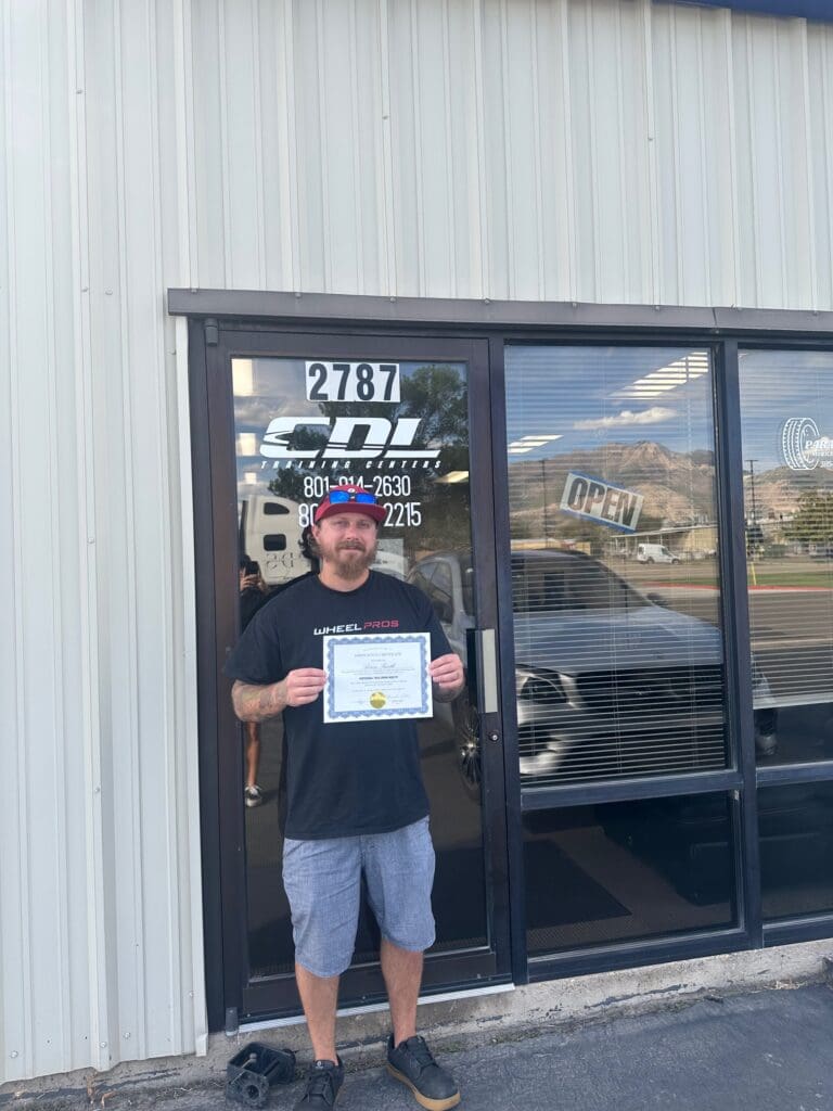 Person holding certificate outside a building.